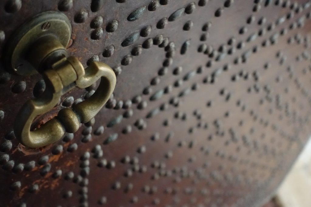 The stunningly intricate studding on a leather and wood entryway door. 