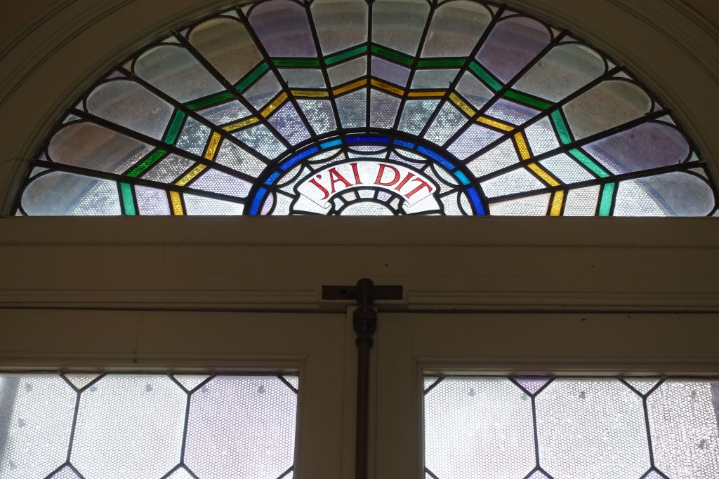 Multi-colored stained glass window inside the Vizcaya home, French inscription reads: "I said"